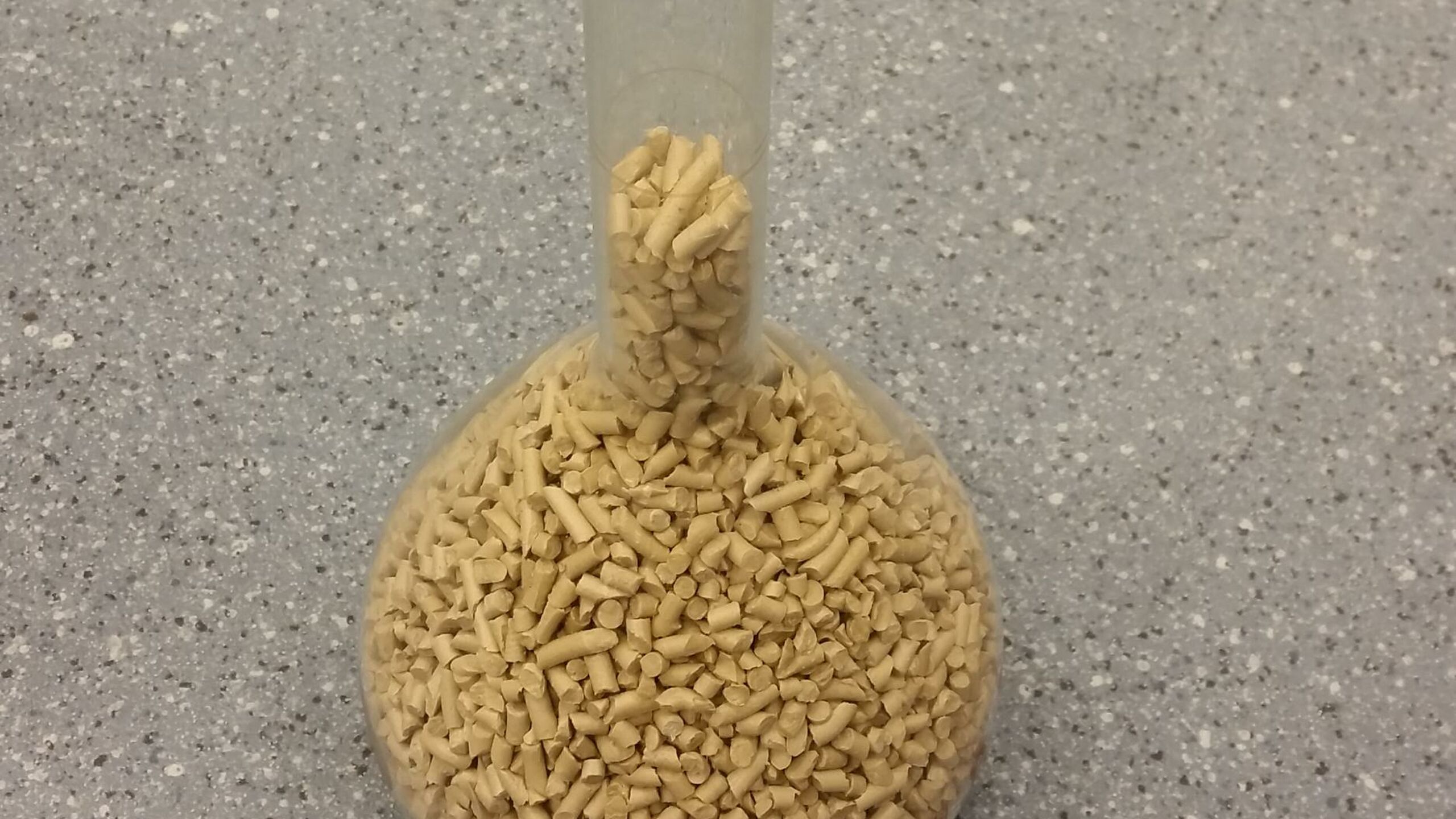 Een reageerbuis met plastic korrels gemaakt uit afvalwater.