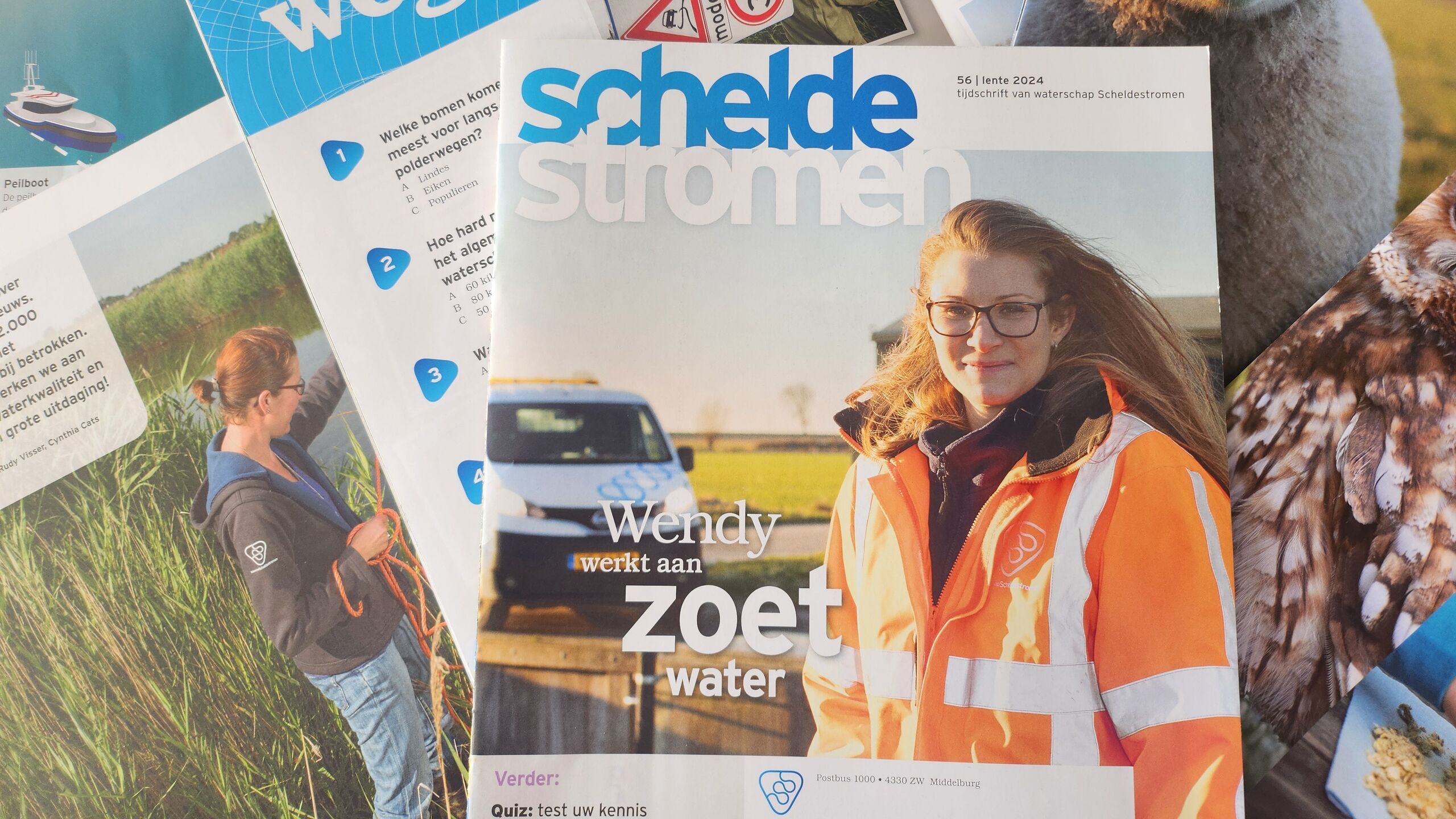De cover van tijdschrift Scheldestromen lente 2024 met verschillende opengeslagen pagina's op de achtergrond