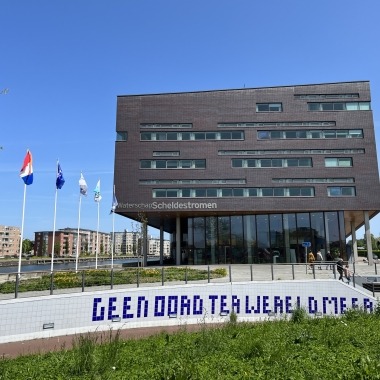 Het kantoor in Middelburg met de op de voorgrond een fietstunneltje en vlaggenmasten.