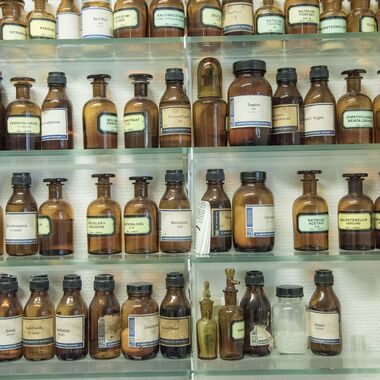 Een rek vol oude bruine medicijnflesjes.